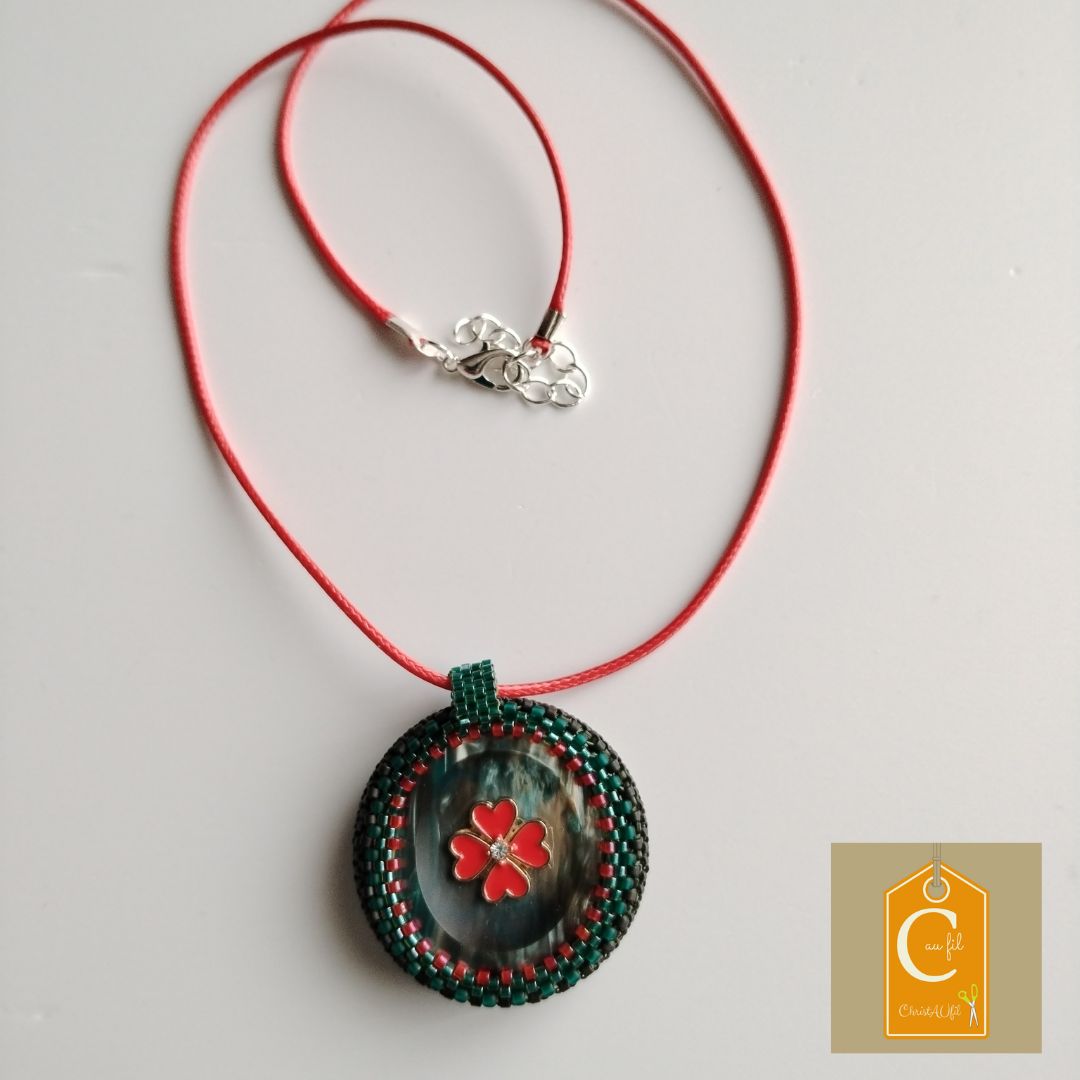 Pendentif bouton irisé vert avec une fleur rouge au centre