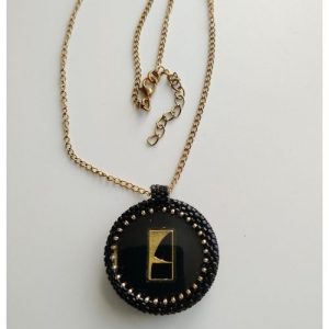Médaillon rond, bouton noir brillant et motif géométrique or - pendentif chic et moderne sur chaine dorée