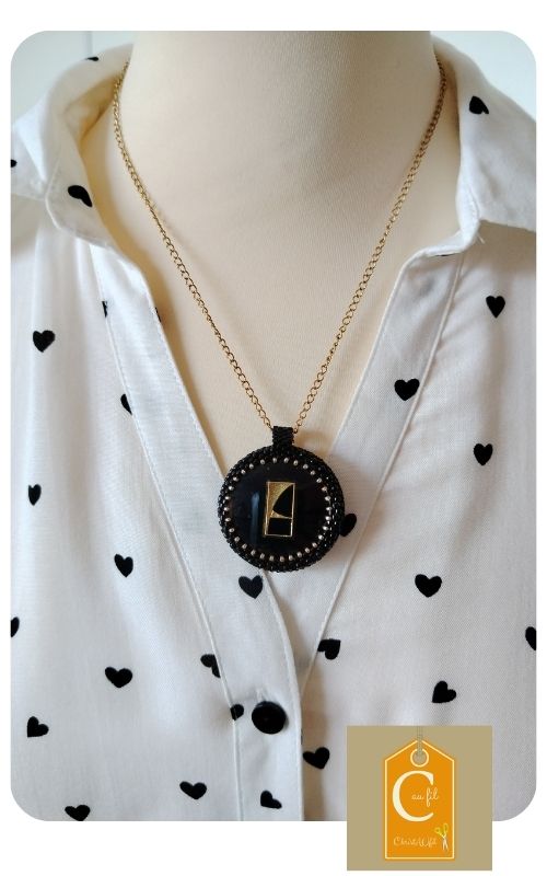 Médaillon rond, bouton noir brillant et motif géométrique or - pendentif chic et moderne sur chaine dorée
