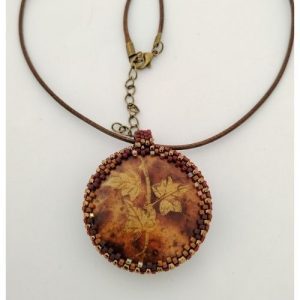 médaillon aux teintes brûlées et feuilles dorées