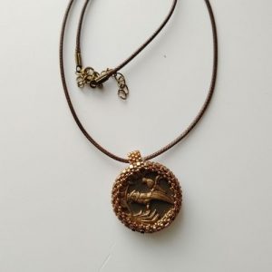 Un fragment de jardin suspendu au cœur d'une broderie de perles, comme une aquarelle que l'on porte sur soi.