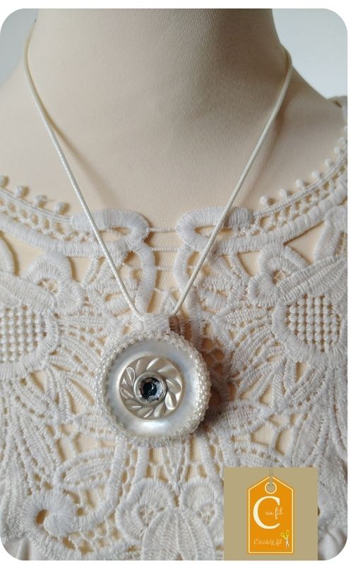 Douceur nacrée d'un bouton vintage et élégance florale d'un papier japonais bordeaux et or.